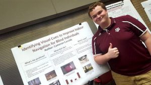 Cameron Cassidy standing in front of a research poster