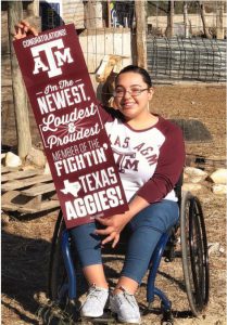 Photo: Briana Bazan, wheelchair user, hold her admissions congratulations poster